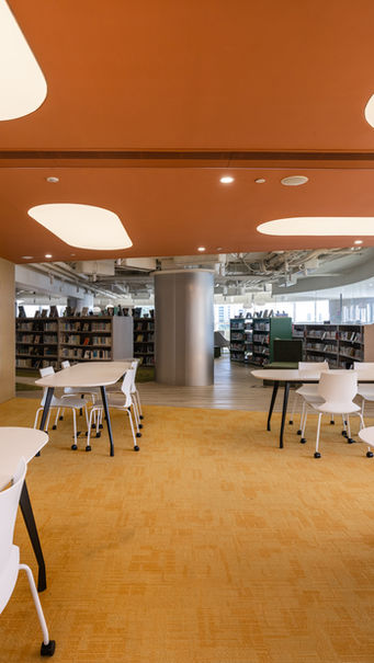 SECONDARY LIBRARY, VSA, Kindergarten Design

Modern library interior designed by MAD Studio, featuring sleek white tables and chairs, vibrant orange ceiling, and built-in bookshelves. The contemporary open space offers a calming atmosphere with natural light and an inviting layout. 