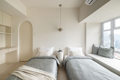 Modern minimalist bedroom design with neutral tones and natural light, showcasing stylish interior by MAD Studio. Twin beds, cozy textiles, and chic decor highlight the latest in contemporary home design trends. Interior design firm specializing in luxury, comfort, and elegance.