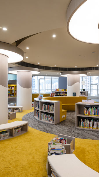 PRIMARY LIBRARY,  VSA, Kindergarten Design

Modern library interior design by MAD Studio featuring circular architectural elements and contemporary lighting. The space showcases curved bookshelves, vibrant yellow carpeting, and natural light from large windows, creating a welcoming and stylish environment. Ideal for innovative interior design enthusiasts.
